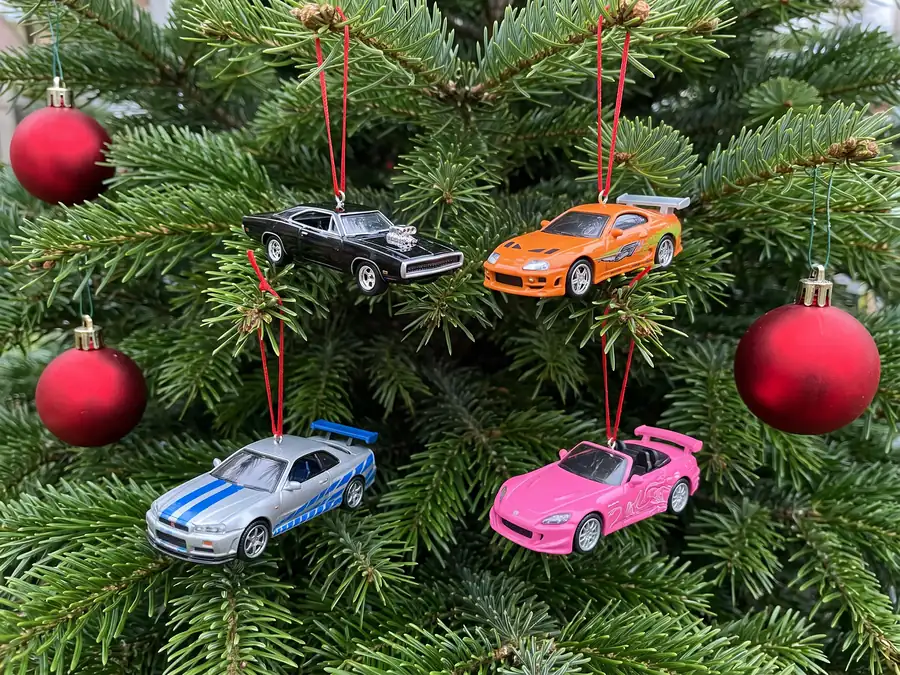 Mini car ornaments hanging on a Christmas tree